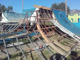 Ossature en métal et en bois d'une rampe courbe en chantier, accolée à une rampe bleue