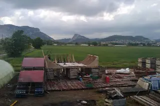 Premières rampes en bois sur un plancher de palettes, champs et montagnes sous un ciel couvert
