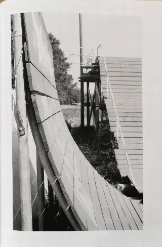 Page de magazine en noir et blanc montrant une grande courbe en planches de bois et une rampe derrière