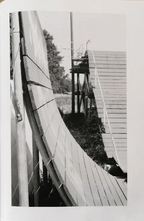 Page de magazine en noir et blanc montrant une grande courbe en planches de bois et une rampe derrière