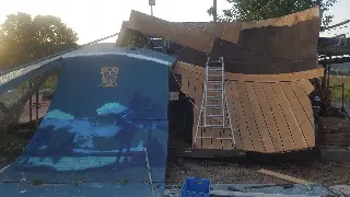 Nouvelle rampe en planches de bois clair avec une échelle, à côté d'une rampe bleue peinte