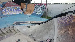Courbe en béton fraîchement coulée au pied d'une plaque marquée « Tetanos Park », rampes graffées autour