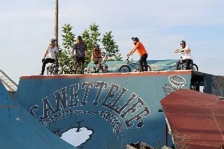 Six riders avec leurs BMX alignés en haut d'une rampe bleue marquée « Canettelife »